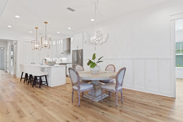90 Basal St, Inlet Beach, FL 32461 - dining room with a chandelier, a decorative wall, light wood-style floors, recessed lighting, and wainscoting