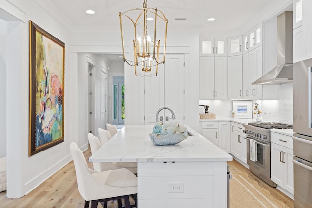 90 Basal St, Inlet Beach, FL 32461 - kitchen featuring appliances with stainless steel finishes, wall chimney range hood, a chandelier, an island with sink, and white cabinets