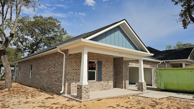 4200 Ida Coon Cir, Niceville, FL 32578 - view of side of home featuring brick siding, board and batten siding, a patio, and a garage