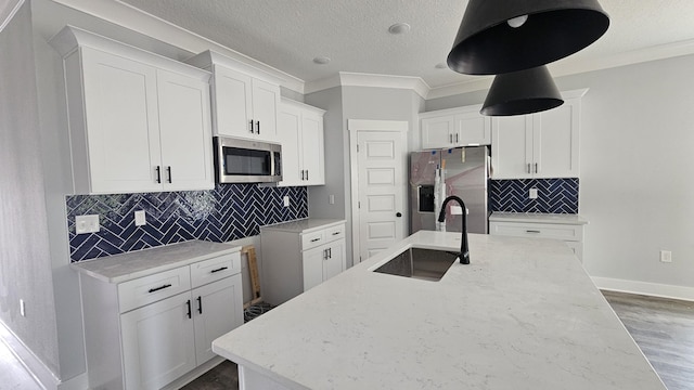 4200 Ida Coon Cir, Niceville, FL 32578 - kitchen with appliances with stainless steel finishes, a sink, crown molding, a center island with sink, and baseboards