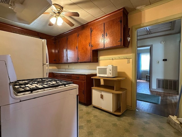 510 E Fisher St, Pensacola, FL 32503 - kitchen featuring white appliances, brown cabinetry, light countertops, ceiling fan, and visible vents