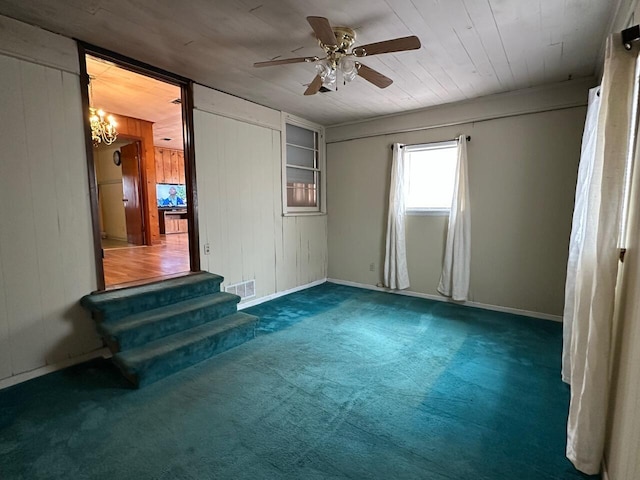 510 E Fisher St, Pensacola, FL 32503 - carpeted spare room with wood ceiling, stairway, visible vents, wooden walls, and ceiling fan with notable chandelier