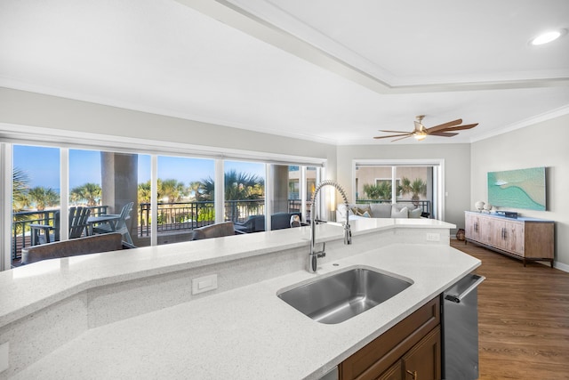 kitchen with a sink, ornamental molding, light stone countertops, and stainless steel dishwasher