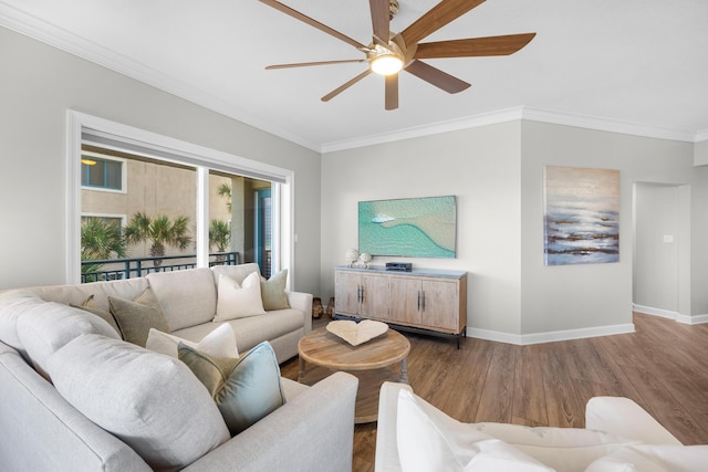 living room with crown molding, baseboards, and a ceiling fan