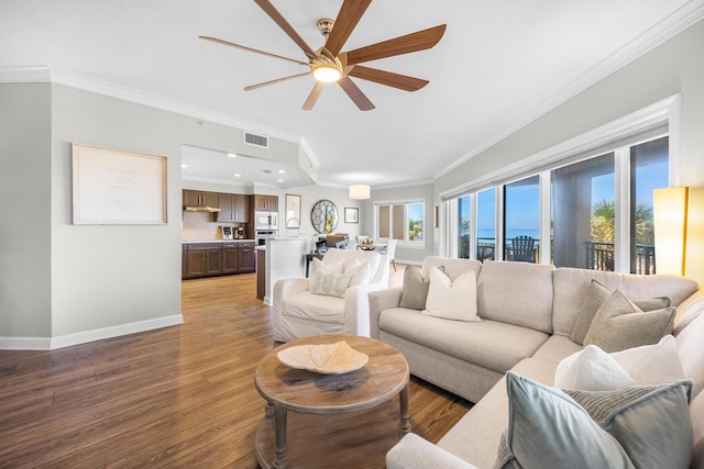 living room with light wood-style floors, plenty of natural light, a ceiling fan, visible vents, and ornamental molding