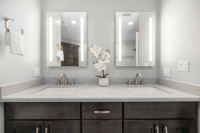 full bath featuring double vanity, visible vents, a sink, and recessed lighting