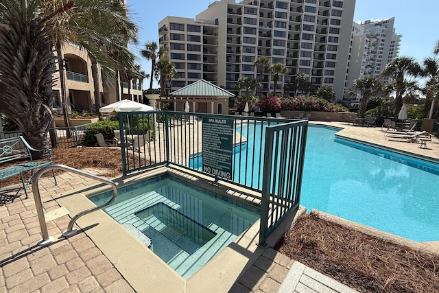 community pool with a patio, a gazebo, and a hot tub
