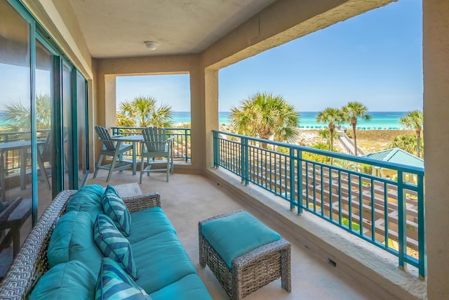 balcony with a water view and a view of the beach