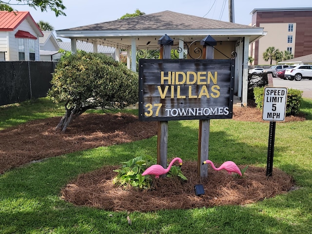 community sign featuring a yard and fence