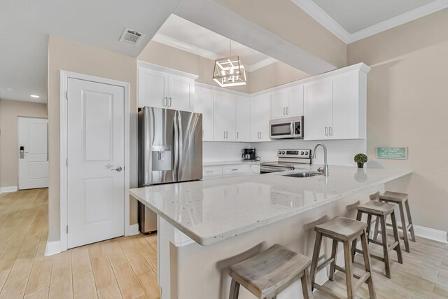 732 Scenic Gulf Dr Unit D103, Miramar Beach, FL 32550 - kitchen with a sink, a peninsula, stainless steel appliances, ornamental molding, and visible vents