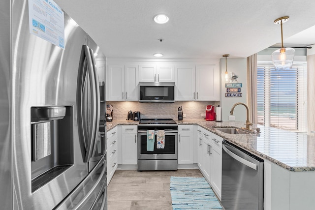 11807 Front Beach Rd # 1-309, Panama City Beach, FL 32407 - kitchen featuring a peninsula, a sink, appliances with stainless steel finishes, and white cabinetry