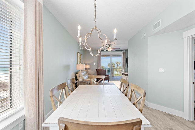 11807 Front Beach Rd # 1-309, Panama City Beach, FL 32407 - dining room with visible vents, baseboards, ceiling fan with notable chandelier, and light wood-style floors