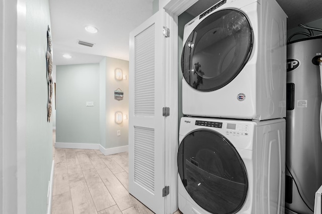 11807 Front Beach Rd # 1-309, Panama City Beach, FL 32407 - washroom featuring laundry area, light wood-style floors, baseboards, visible vents, and stacked washer and clothes dryer