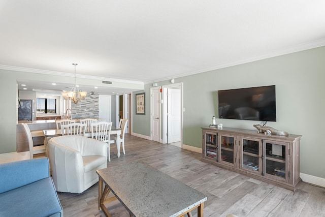 291 Scenic Gulf Dr Unit 900, Miramar Beach, FL 32550 - living area with a chandelier, baseboards, light wood finished floors, and ornamental molding
