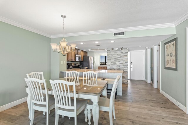 291 Scenic Gulf Dr Unit 900, Miramar Beach, FL 32550 - dining room with crown molding, a chandelier, baseboards, and light wood-type flooring