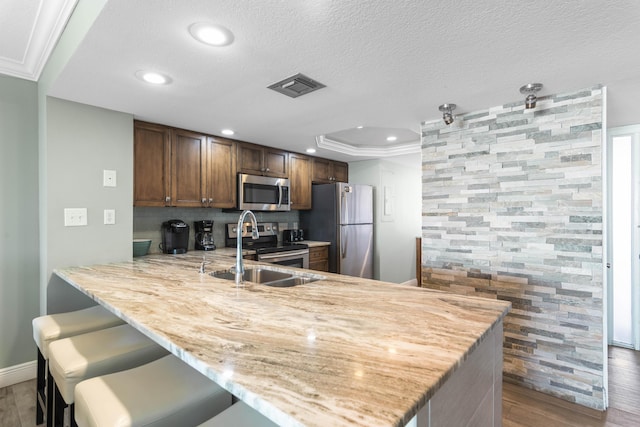 291 Scenic Gulf Dr Unit 900, Miramar Beach, FL 32550 - kitchen featuring stainless steel appliances, a sink, a peninsula, wood finished floors, and recessed lighting