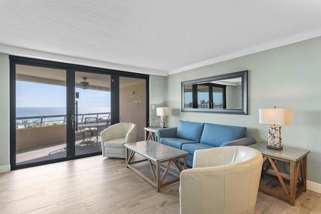 291 Scenic Gulf Dr Unit 900, Miramar Beach, FL 32550 - living room with light wood-type flooring, crown molding, baseboards, a water view, and a ceiling fan