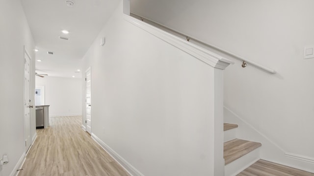 hall with light wood-type flooring, baseboards, visible vents, recessed lighting, and stairs