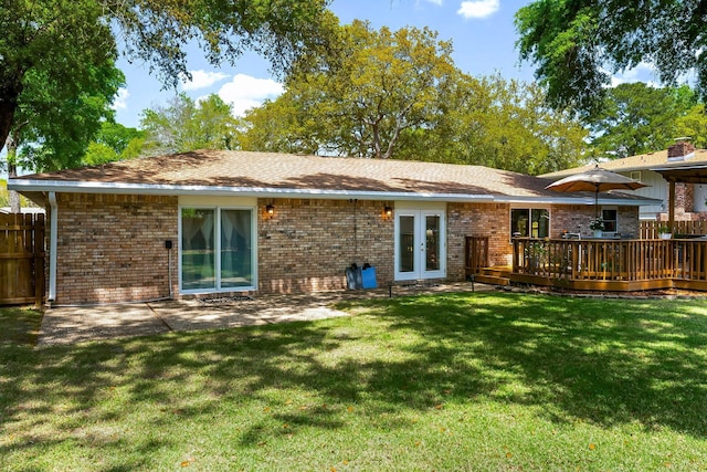rear view of house with french doors, brick siding, and a wooden deck