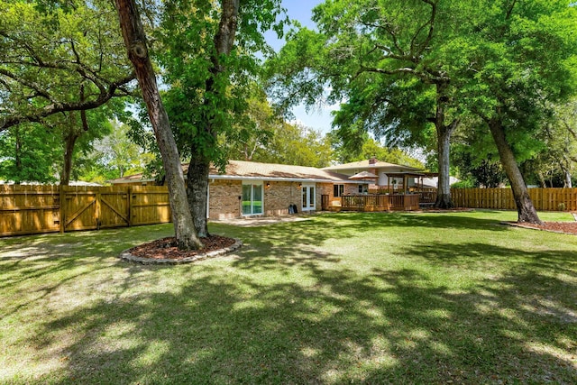 view of yard featuring a deck and a gate