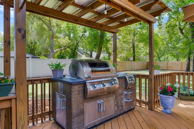 wooden terrace with a grill, a fenced backyard, area for grilling, and view of wooded area