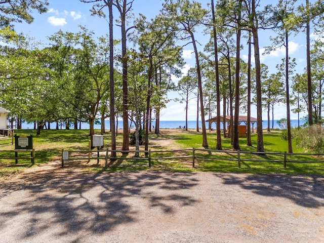 view of community featuring fence and a water view