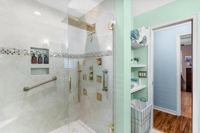 bathroom featuring a shower stall and wood finished floors