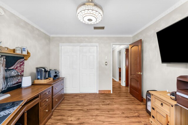 home office featuring light wood-style floors, crown molding, and baseboards