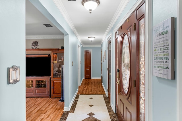hallway with ornamental molding, wood finished floors, baseboards, and inlaid floor details