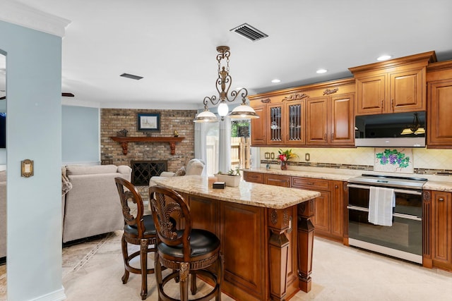 kitchen featuring appliances with stainless steel finishes, open floor plan, brown cabinetry, backsplash, and ornamental molding