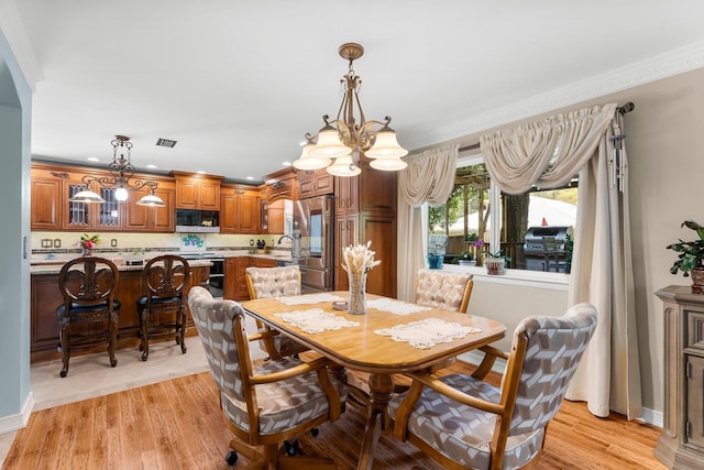 dining room with a chandelier, light wood-type flooring, and recessed lighting