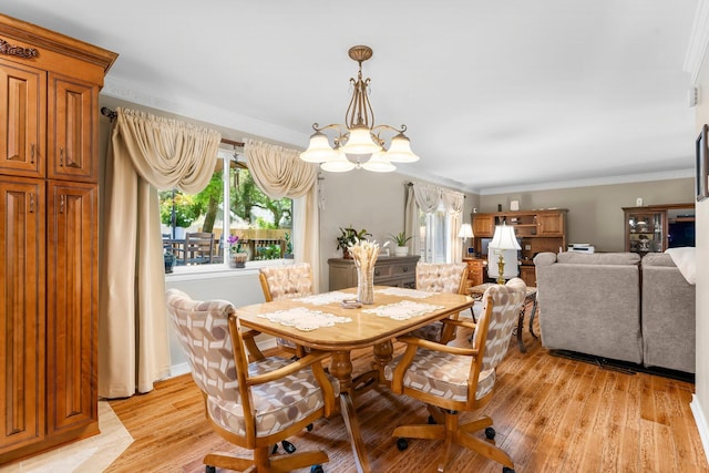 dining space featuring a chandelier, light wood finished floors, and crown molding