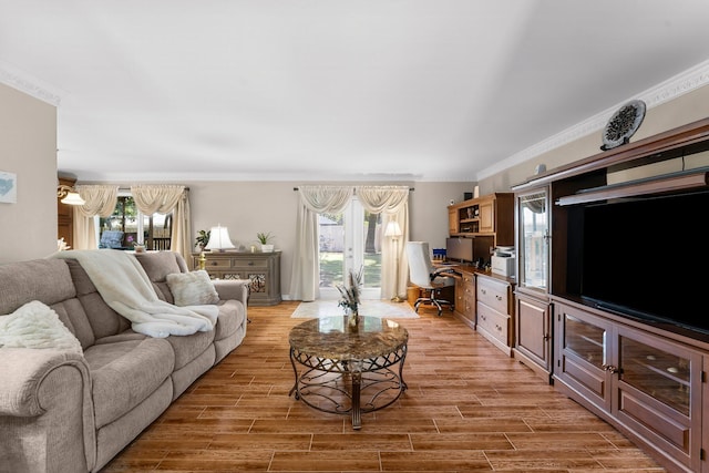 living room featuring ornamental molding, light wood finished floors, and an office area