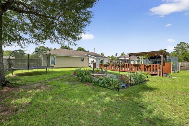 1192 Oakwood Lakes Blvd, Defuniak Springs, FL 32433 - view of yard with a trampoline and a wooden deck