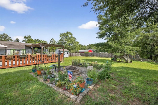 1192 Oakwood Lakes Blvd, Defuniak Springs, FL 32433 - fenced backyard with a fire pit, a deck, and a shed