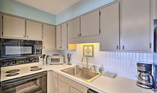 kitchen with a toaster, a sink, electric range, black microwave, and light countertops