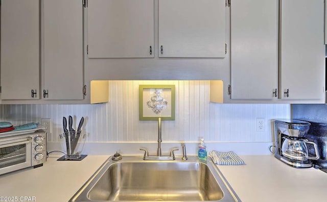 kitchen featuring light countertops, a toaster, and a sink