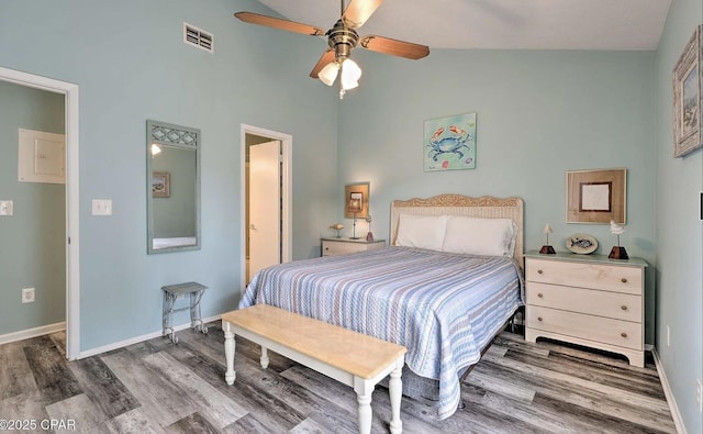 bedroom featuring baseboards, wood finished floors, visible vents, and high vaulted ceiling