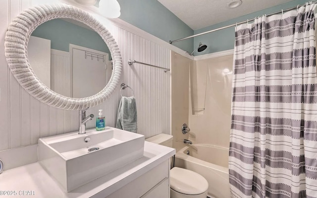 bathroom with vanity, shower / bathtub combination with curtain, and toilet