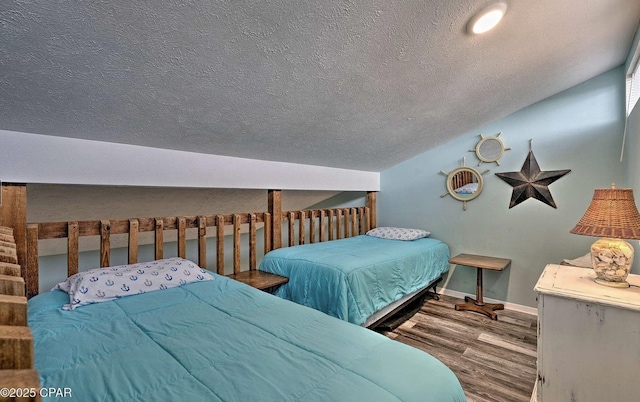 bedroom with lofted ceiling, baseboards, wood finished floors, and a textured ceiling