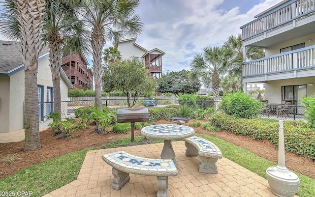 view of community featuring fence and a patio