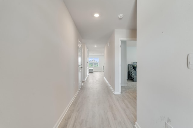 hallway with baseboards, recessed lighting, and light wood-style flooring