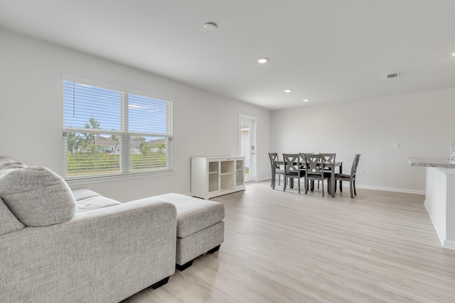 living area with visible vents, light wood-type flooring, recessed lighting, and baseboards