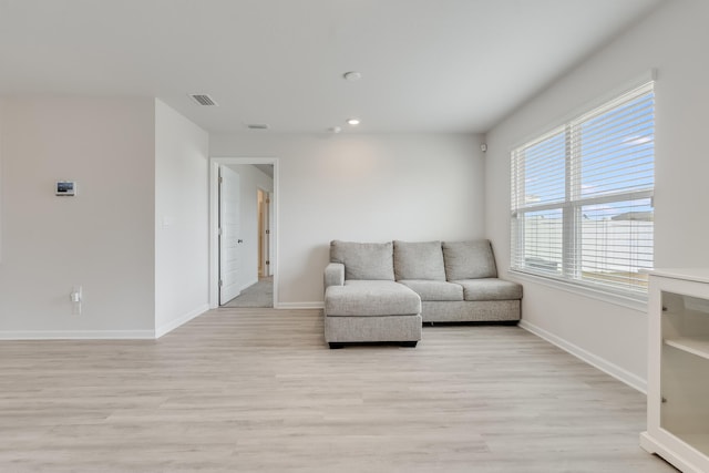 living area featuring visible vents, light wood-type flooring, recessed lighting, and baseboards