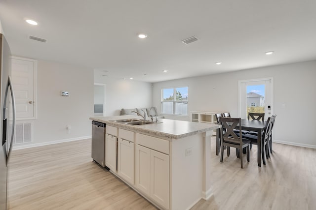 kitchen with stainless steel appliances, light wood-type flooring, a sink, baseboards, and visible vents