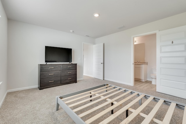 unfurnished bedroom with visible vents, ensuite bathroom, light carpet, and baseboards