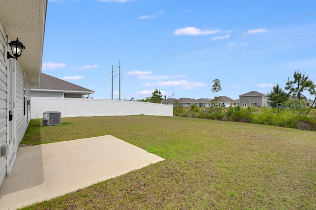 view of yard with fence, central AC unit, a patio area, and a residential view