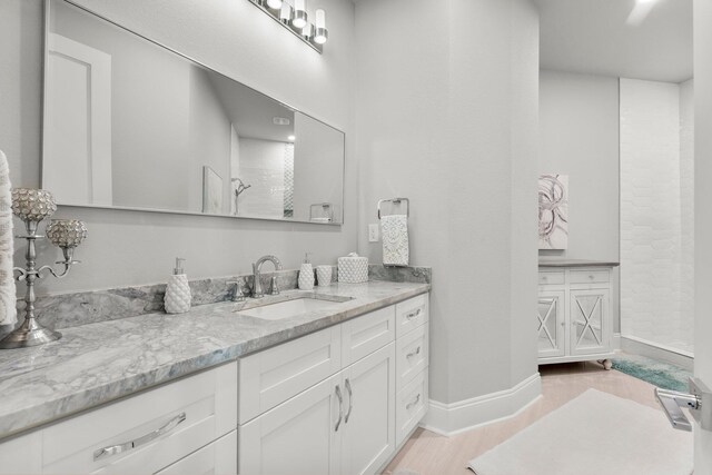 320 Harbor Blvd Unit 1201, Destin, FL 32541 - full bathroom featuring vanity, baseboards, a tile shower, and wood finished floors