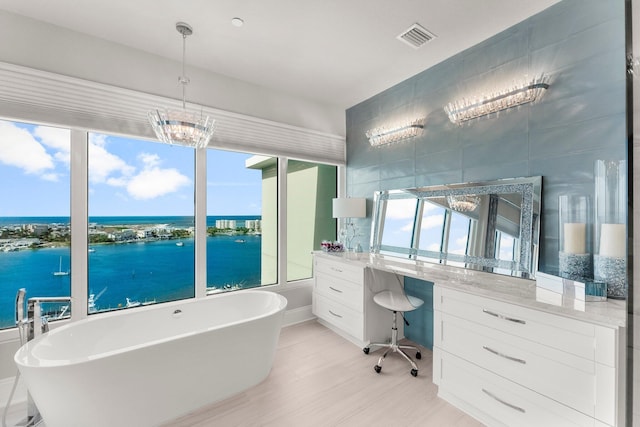 320 Harbor Blvd Unit 1201, Destin, FL 32541 - bathroom featuring vanity, wood finished floors, a water view, visible vents, and a soaking tub