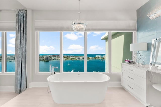 320 Harbor Blvd Unit 1201, Destin, FL 32541 - full bathroom featuring a freestanding bath, baseboards, a water view, and a chandelier